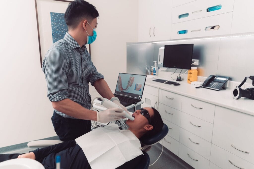 A man is getting a dental exam at a Dentist's office in Surrey Hills.