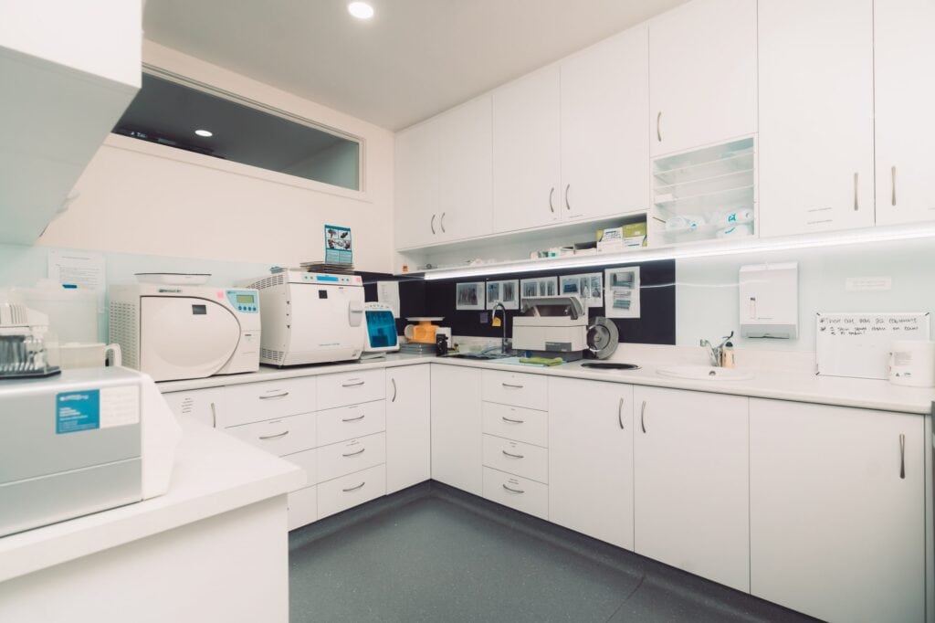 A white kitchen with a lot of equipment in it, perfect for a professional chef or cooking enthusiast.